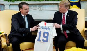 O presidente dos EUA, Donald Trump, dá ao presidente do Brasil, Jair Bolsonaro, uma camisa da seleção de futebol dos EUA durante uma reunião no Salão Oval da Casa Branca , em Washington (EUA).